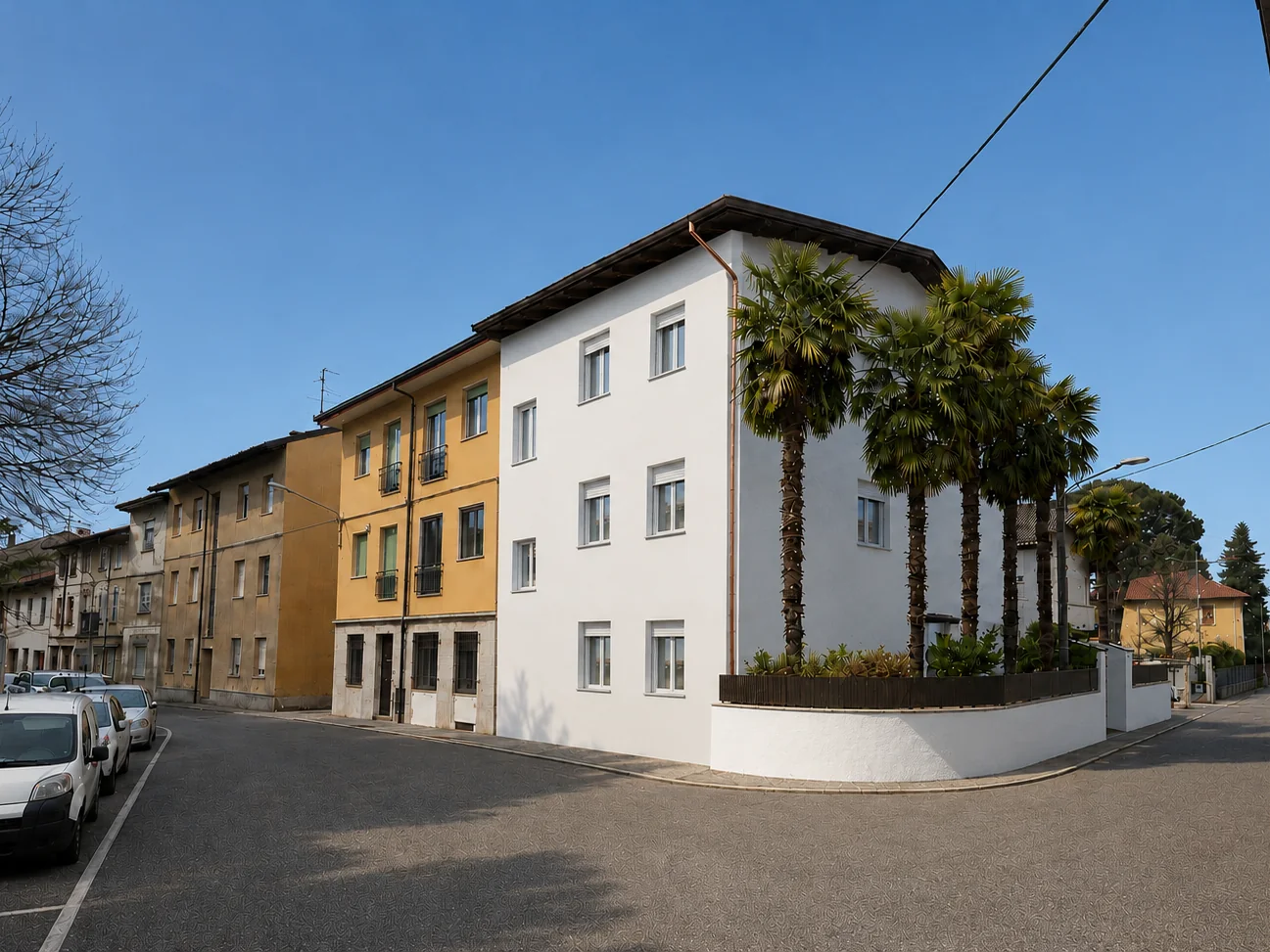 L'angolo della palazzina con le palme e il giardino recintato